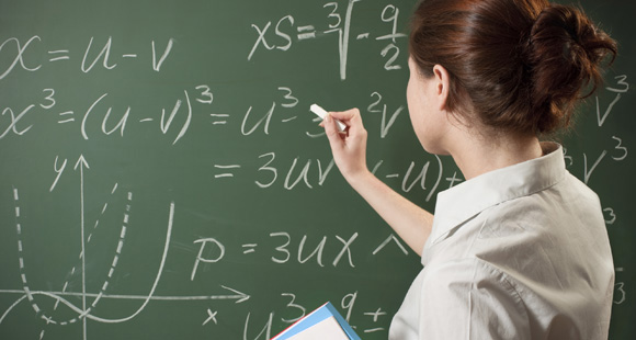 A woman writing on a chalkboard.